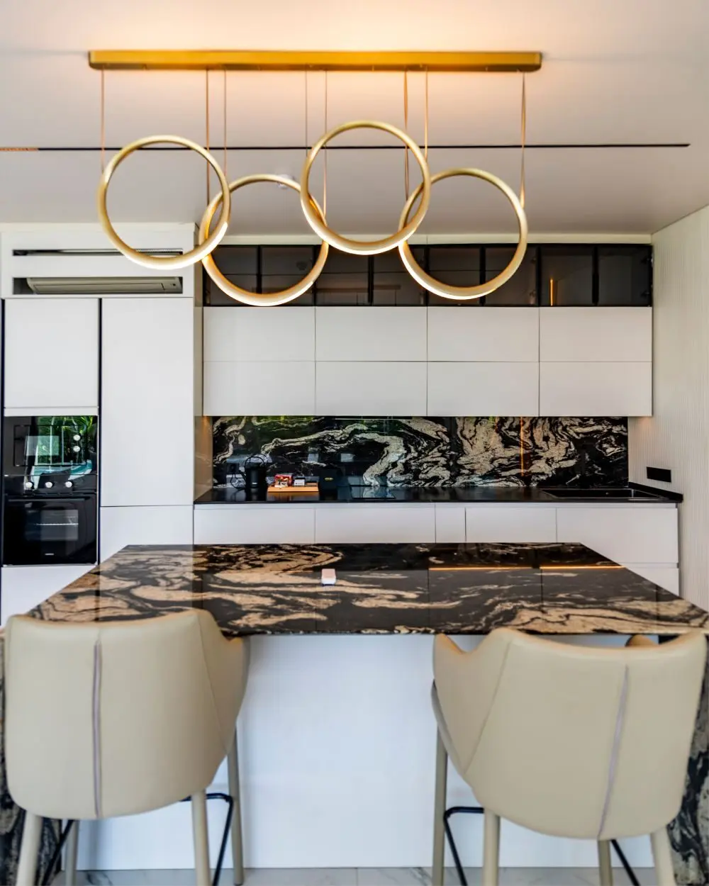 Kitchen island with a stone worktop and pendant lights
