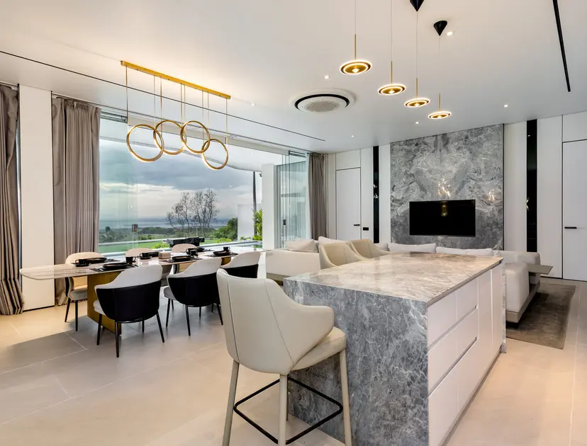 Kitchen island and dining table with the ocean view beyond